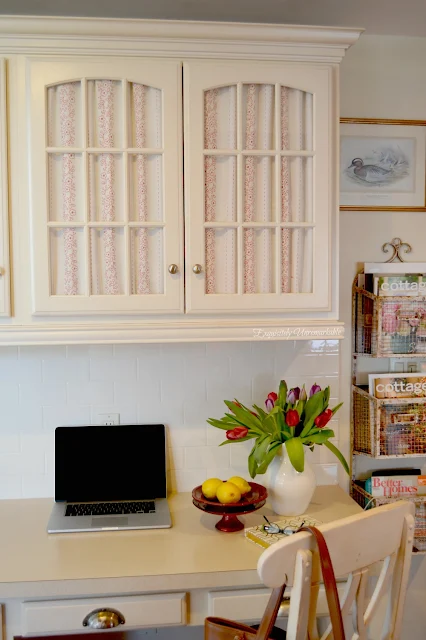 Cottage Style desk area with fabric on glass cabinets