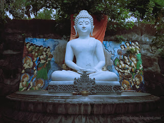 White Buddha meditation Statue Under The Tree At Buddhist Monastery In Bali Indonesia