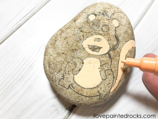 coloring in the ears and tummy on the squirrel painted rock