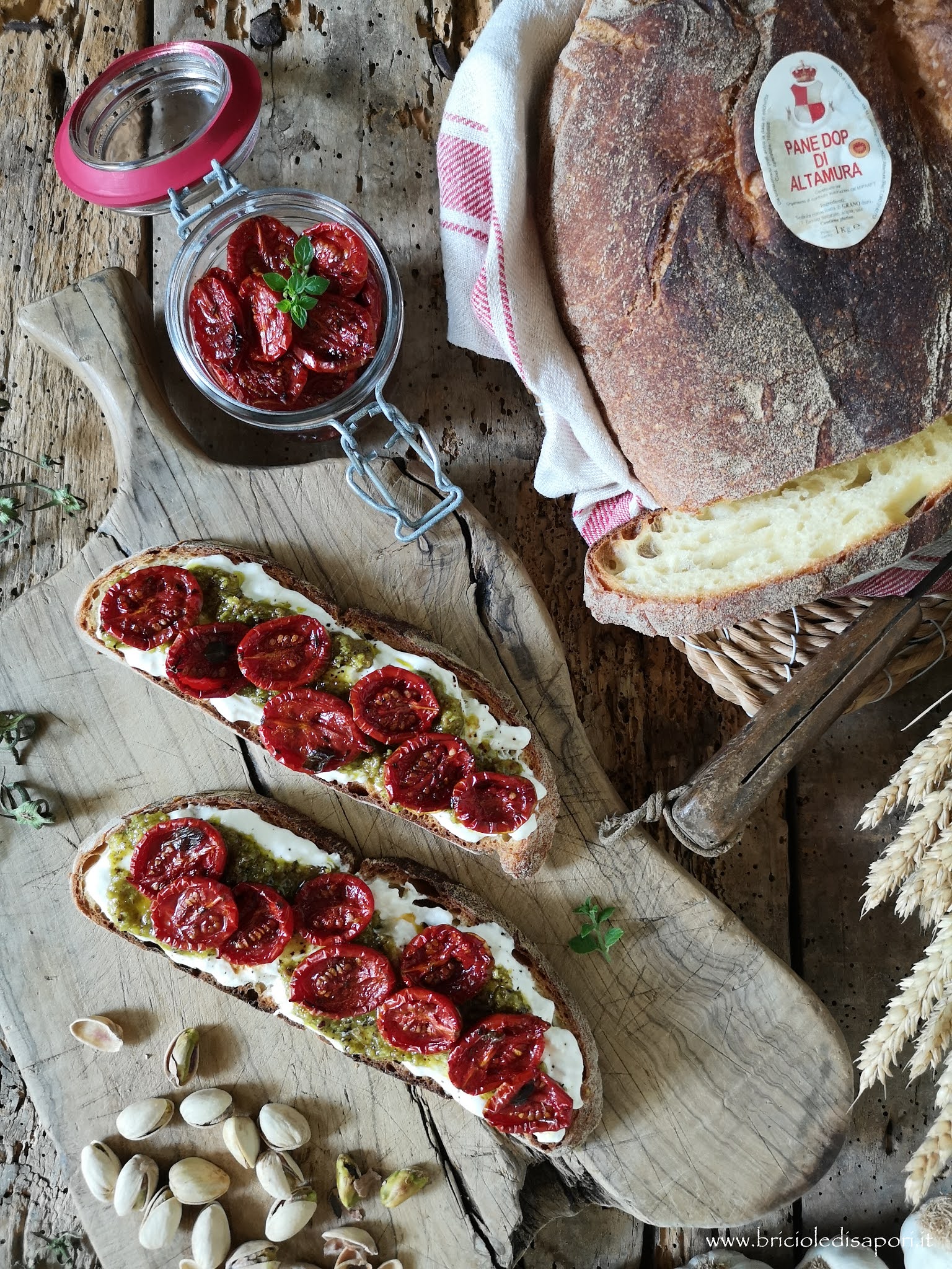 Bruschette con pane di Altamura D.O.P., stracciatella, pesto di pistacchi e pomodorini confit