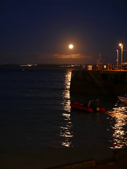 St Ives harbour at night, with the full moon reflected in the water.