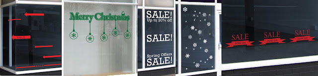 Various window displays, vinyl graphics. Sale arrows, Merry Christmas baubles with a robin, winter snowflakes and sale banners to help get customers into shops.