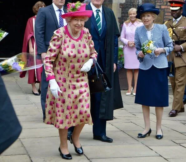 Queen Elizabeth wore a floral satin dress, pink coat and pink hat for visit National Institute of Agricultural Botany