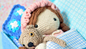 Crochet pattern amigurumi doll girl in bed in pajamas with teddy bear