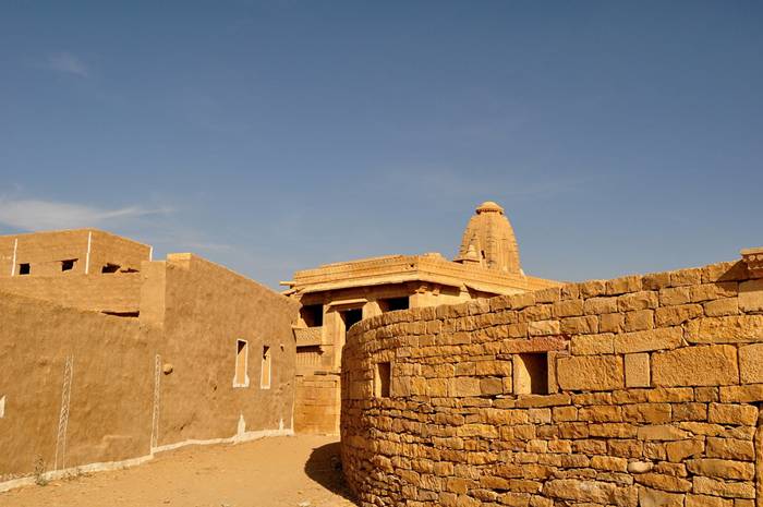 Kuldhara village near Jaisalmer has a very unique history! It is said that the residents of 84 neighboring villages including Kuldhara vacated the villages overnight around 170 years back!! No one is sure where they have gone, but they are believed to have migrated to a place somewhere near Jodhpur. The residents were Paliwal Brahmans — said to be very intelligent, and residing there for about 500 years. So what made them do such an act? Stories say that the ruler of these villages pounded the Paliwals with heavy taxes and treated them very inhumanly; the ruler was unethical and forceful to them. They had no alternative, but to vacate all the 84 villages overnight and just disappear from the vision and reach of the ruler.  When the Paliwals left the villages, they left a curse that nobody can inhabit the villages ever. Residents of Jaisalmer say that there have been some attempts by some families to stay there, but they did not succeed.