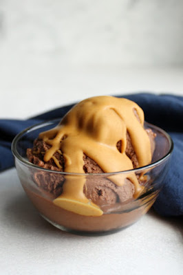 Peanut butter, chocolate and bananas come together to make this dairy free, gluten free, guilt free nice cream treat! It takes almost no effort to make and tastes like a dream! bowl of chocolate peanut butter banana ice cream with peanut butter magic shell on top with blue napkin