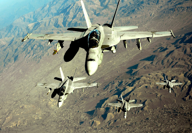 Four U.S. Navy F/A-18 Hornets approach a KC-10 Extender for refueling