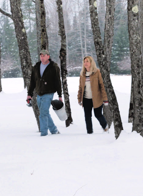 couple walking through the trees in the snow