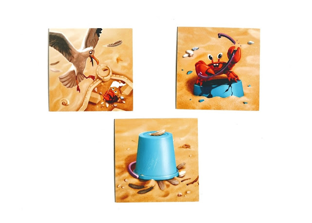 zamki z piasku recenzja gry, na zdjęciu trzy karty ataku z wizerunkiem nadlatującej i atakującej kraba mewy, karta z krabem atakującym wiaderko oraz z wiaderkiem, które nakryło mewę a na około widać rozrzucone pióra