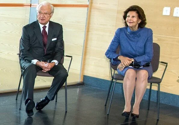 Queen Silvia wore and blue jacket and skirt, skirt suit. She is wearing gold earrings and gold bracelet