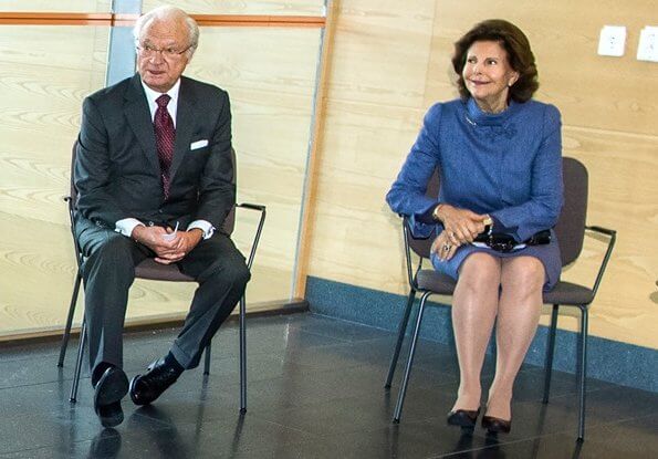 Queen Silvia wore and blue jacket and skirt, skirt suit. She is wearing gold earrings and gold bracelet