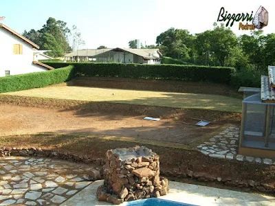 Na construção da casa em Atibaia-SP, a terraplanagem do campo de futebol pronta com a execução do plantio da grama esmeralda pronto e fazendo os caminhos de pedra, os murinhos de pedra e iniciando a execução do paisagismo.