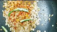 Sauteeing chopped onion with spices and slits green chili for paneer masala recipe
