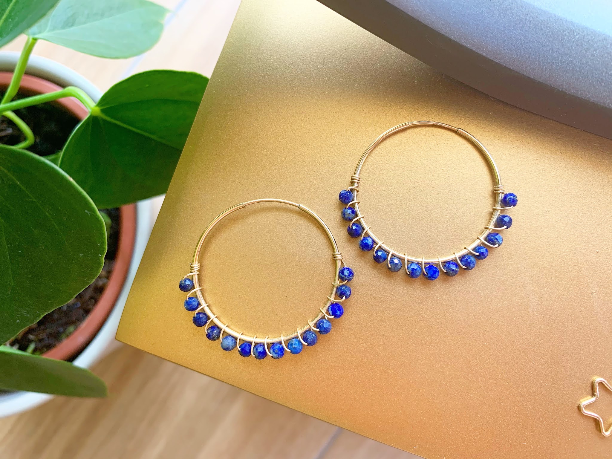 Binichohan Lapis Lazuli Wrapped Hoop Earrings Binichohan Lapis Hoop Earrings on a gold surface