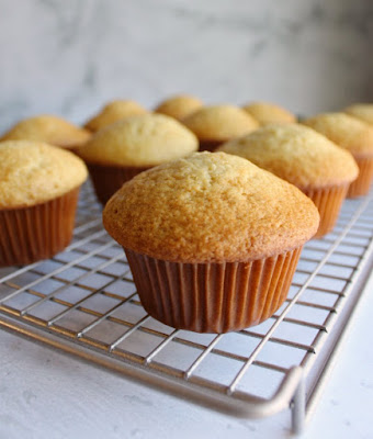 Lightly spiced cupcakes kissed with green apple syrup and topped with easy caramel cream cheese frosting are as pretty as they are tasty. Garnish with an apple chip and drizzle of caramel sauce for extra fall flare. freshly baked cozy apple cupcakes fresh from the oven cooling on a baking rack