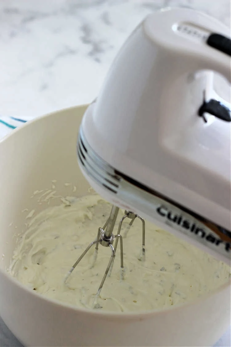 Hand mixer mixing up ingredients for homemade Lawson's Chip Dip