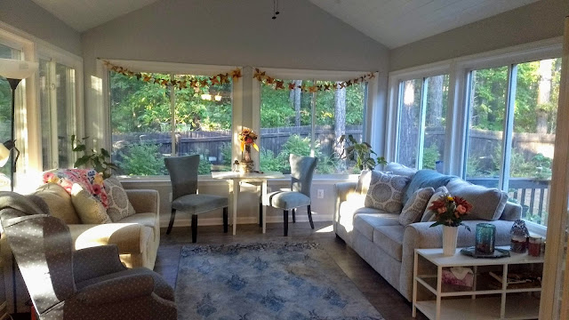 View of a sunroom, forest visible through the windows
