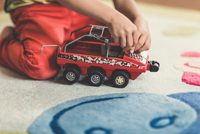 Child playing with toys on a carpet