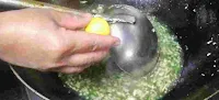 Pouring lemon juice in lemon coriander soup in wok