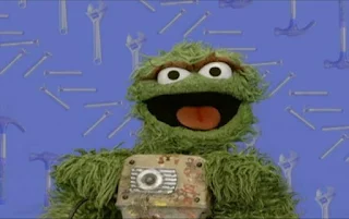Oscar the Grouch appears with a jackhammer in his hands. Oscar then uses the jackhammer. Sesame Street Elmo's World Building Things Quiz