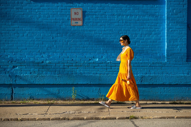orange dress against blue brick wall orange dress against blue bricks