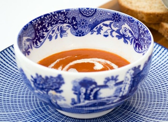 Tomato soup with a swirl of cream in a blue and white bowl