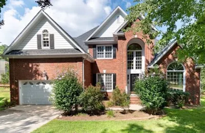 2 storey home with red bricks and nice landscaping.