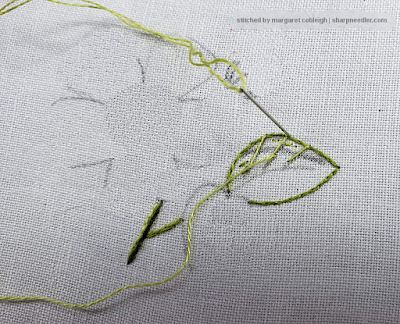 Stitching the first row of a needlepainted leaf by stitching from the inside of the leaf over the split stitched edge