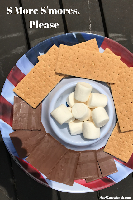 S'mores ingredients on a plate with the words "S More S'mores, Please" digitally written on top.