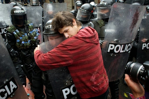 35 moments of violence that brought out incredible human compassion - a student protesting education reform hugs a policeman