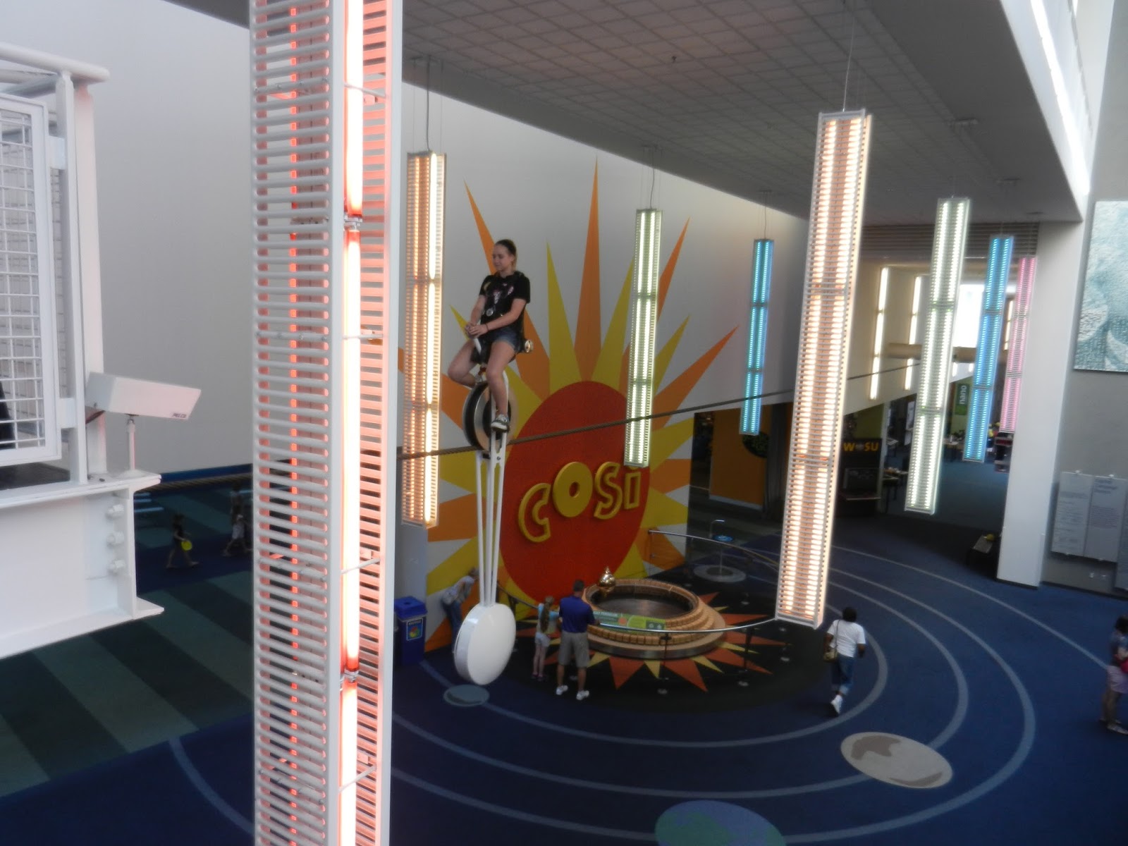 beauty of everyday life COSI stuck on the unicycle over the lobby