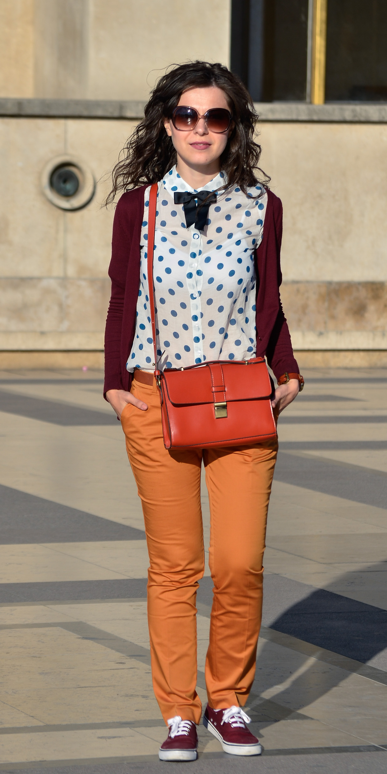 preppy fall outfit in Paris mustard pants burgundy sweater sneakers H&M orange satchel bag dotted shirt blue dots black bow tie champs elysees jardin de tuileries eiffel tower