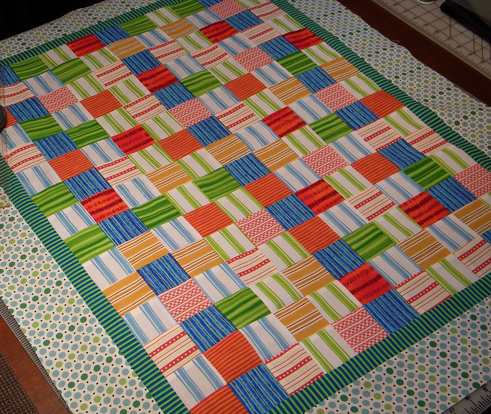 The Quilted Librarian Baby quilt update Top with borders and a peek