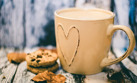 A cup of coffee and a pile of chocolate chip cookies.