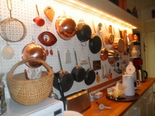 Wall with peg board holding pots and pans
