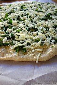A mix of fresh herbs and a blend of tangy cheeses on roasted garlic oil for a light summer pizza.