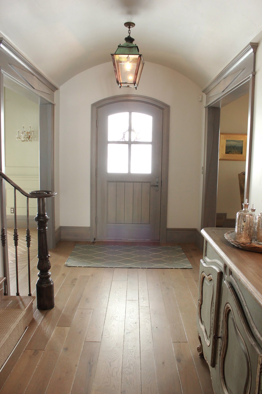 Magnificent Gustavian French entry in stone cottage with rustic interiors, reclaimed wood ceilings, blue-grey, green, and collected European antiques. Designed by Desiree Ashworth. Find ideas for grey, blue, and green paint colors.