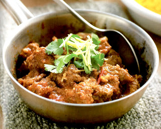 Spicy Pork Curry: Shoulder of pork in a spicy gravy base garnished with coriander in the pan it was prepared in