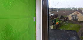 Bright green paint on a wall and snow hitting a window
