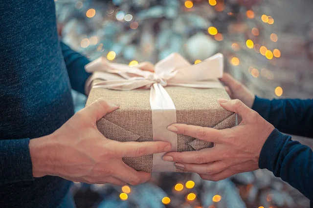 Alguém está feliz dando um presente e outra pessoa feliz também por receber