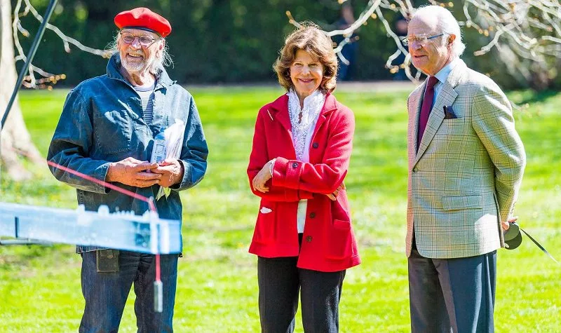 Queen Silvia wore a red jacket and white ruffled blouse from Newhouse, black trousers