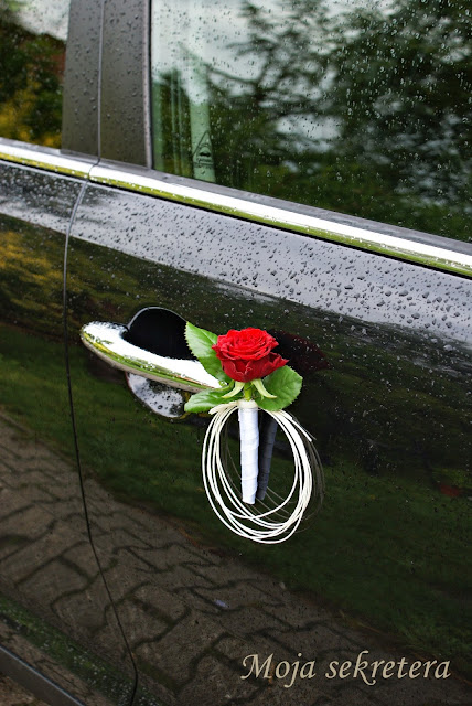 drzwi samochodu ślubnego z czerwoną różą