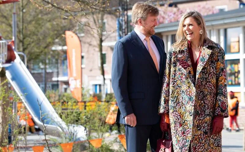 Queen Maxima wore a floral brocade long coat from Oscar de la Renta, and red LaPerm blazer, Lykoi trousers and Korat red blouse from Claes Iversen