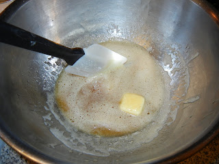 butter in a metal bowl with a rubber spatula 