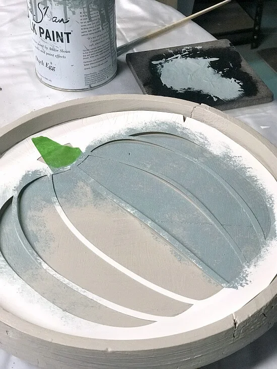 Stenciling a pumpkin on a round tray