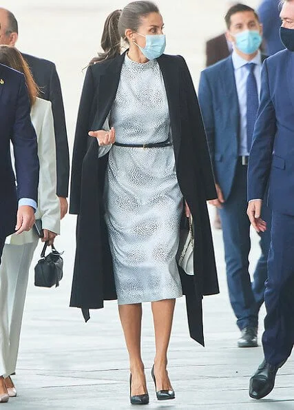 Queen Letizia wore a printed didi dress by Cherubina, and black pumps by Manolo Blahnik. She carries awhite leather shoulder bag by Furla