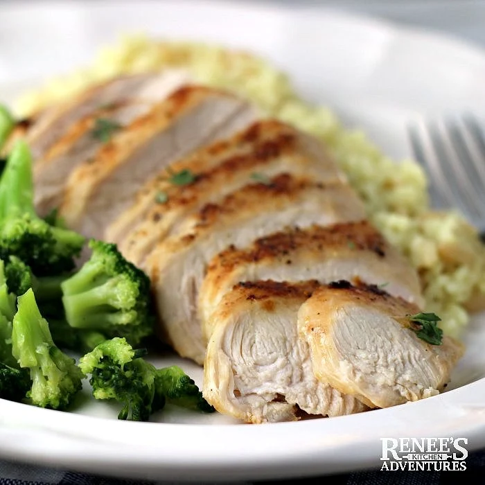 Pan Fried Chicken Breast on plate close up with broccoli on the side