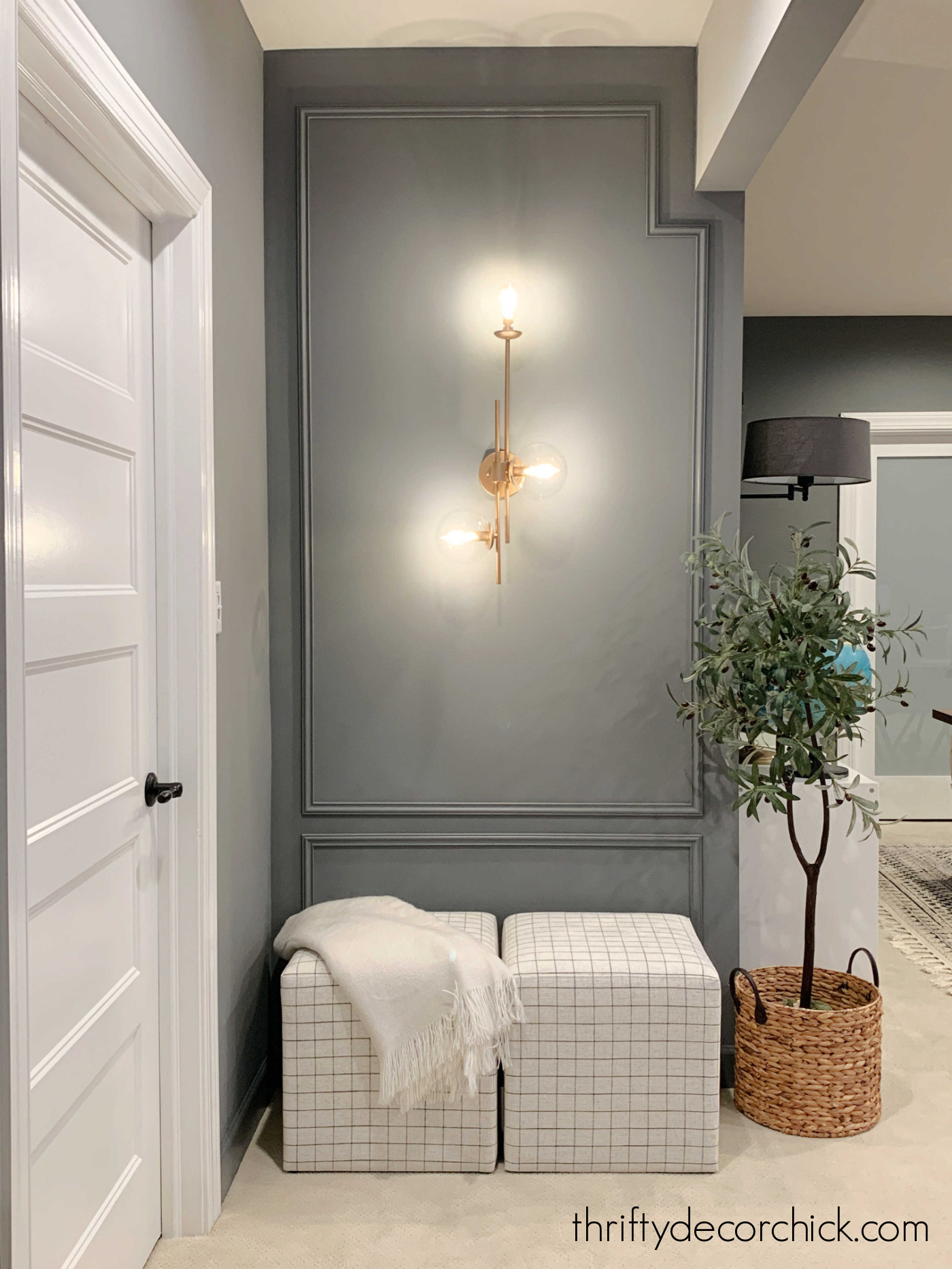 accent wall with box trim and brass sconce