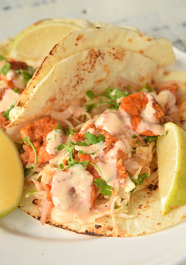 spicy delicious shrimp tacos recipe with cabbage slaw in a white plate