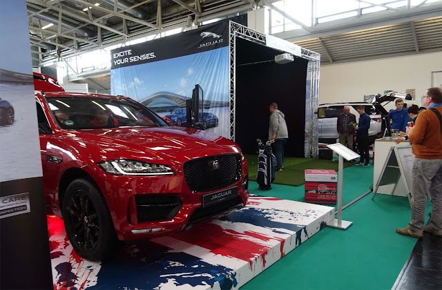  Roter Jaguar F-Pace auf britischem Logo, Leute stehen für Probegolf an